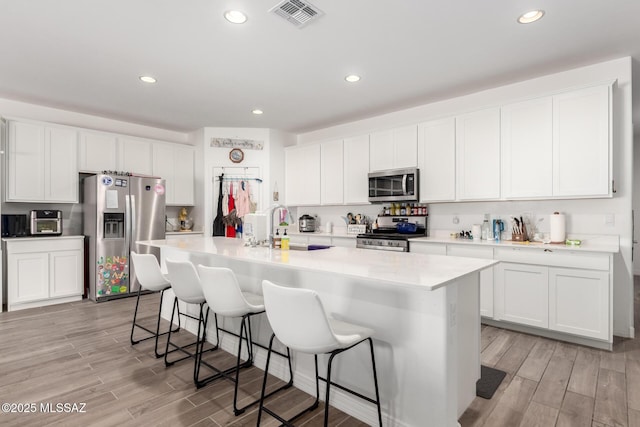5568 W Summer Vw Dr, Marana, AZ 85658 - kitchen featuring appliances with stainless steel finishes, a sink, light wood-style floors, a breakfast bar, and recessed lighting