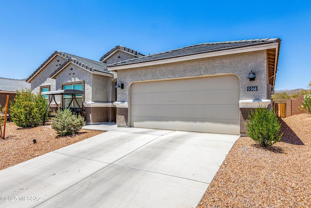 5568 W Summer Vw Dr, Marana, AZ 85658 - view of front of house featuring driveway, stucco siding, an attached garage, and a tiled roof