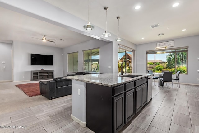 11874 N Raphael Way, Tucson, AZ 85742 - kitchen featuring a sink, dark cabinetry, dishwasher, a kitchen island with sink, and baseboards