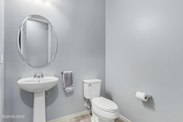 11874 N Raphael Way, Tucson, AZ 85742 - half bathroom with toilet, baseboards, and wood finished floors