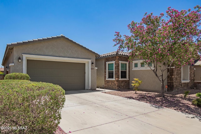 11874 N Raphael Way, Tucson, AZ 85742 - view of front of home with stucco siding, driveway, an attached garage, stone siding, and a tiled roof