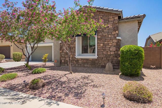 11874 N Raphael Way, Tucson, AZ 85742 - view of front of property with stone siding, stucco siding, concrete driveway, a garage, and a tile roof
