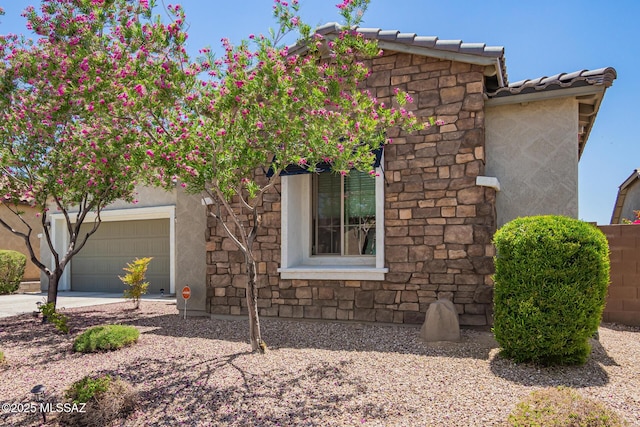 11874 N Raphael Way, Tucson, AZ 85742 - view of front of home with stone siding, a tiled roof, stucco siding, and concrete driveway