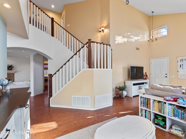 9880 E Cisco Ct, Tucson, AZ 85748 - living area with a towering ceiling, wood finished floors, arched walkways, stairs, and baseboards