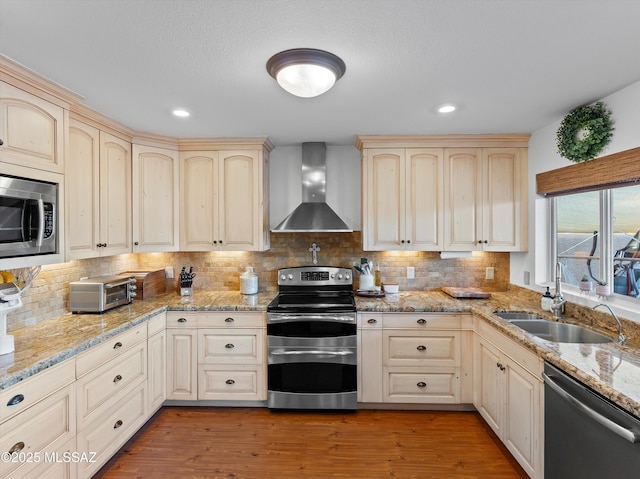 9880 E Cisco Ct, Tucson, AZ 85748 - kitchen with wall chimney exhaust hood, stainless steel appliances, cream cabinets, a sink, and backsplash