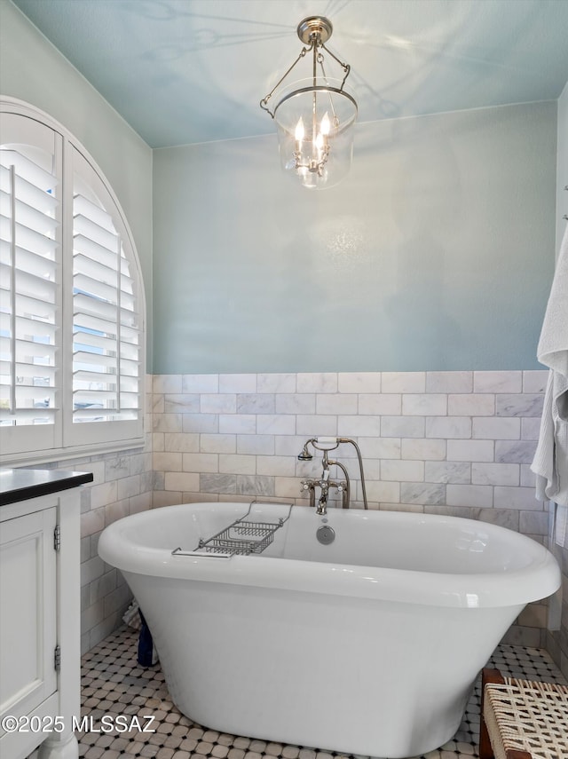 9880 E Cisco Ct, Tucson, AZ 85748 - full bath with tile walls, tile patterned flooring, a freestanding tub, a chandelier, and wainscoting