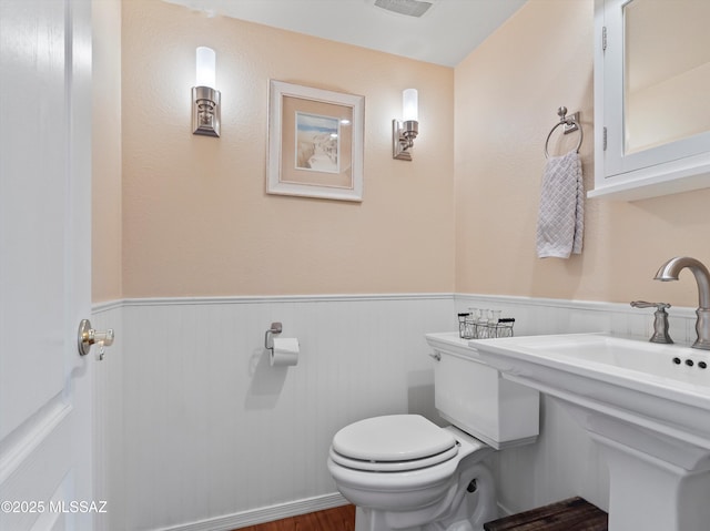 9880 E Cisco Ct, Tucson, AZ 85748 - half bath with a wainscoted wall, toilet, and wood finished floors