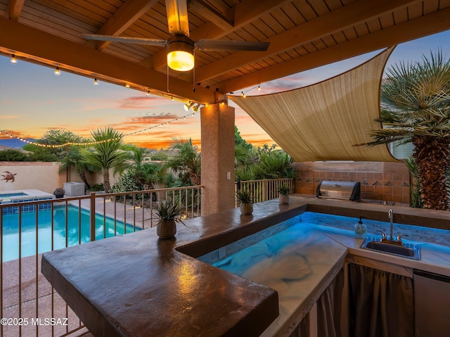 9880 E Cisco Ct, Tucson, AZ 85748 - pool at dusk with a sink, an in-ground hot tub, ceiling fan, a fenced backyard, and a patio