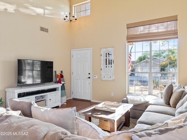 9880 E Cisco Ct, Tucson, AZ 85748 - living area featuring dark wood finished floors, a high ceiling, healthy amount of natural light, a chandelier, and baseboards