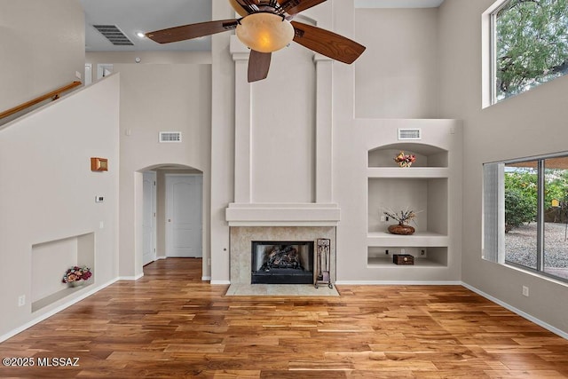 520 E Marshall Peak Dr, Oro Valley, AZ 85755 - unfurnished living room with a high ceiling, built in shelves, a ceiling fan, wood finished floors, and baseboards