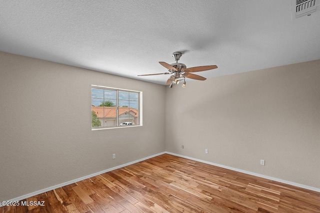 520 E Marshall Peak Dr, Oro Valley, AZ 85755 - empty room featuring light wood finished floors, a ceiling fan, baseboards, and a textured ceiling