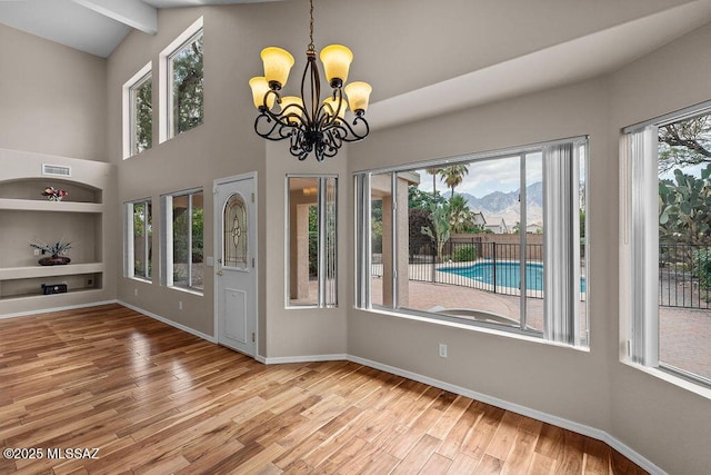 520 E Marshall Peak Dr, Oro Valley, AZ 85755 - unfurnished dining area with a chandelier, plenty of natural light, wood finished floors, baseboards, and high vaulted ceiling