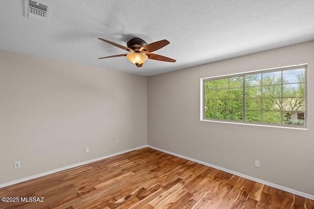 520 E Marshall Peak Dr, Oro Valley, AZ 85755 - spare room featuring wood finished floors, baseboards, a ceiling fan, and a textured ceiling
