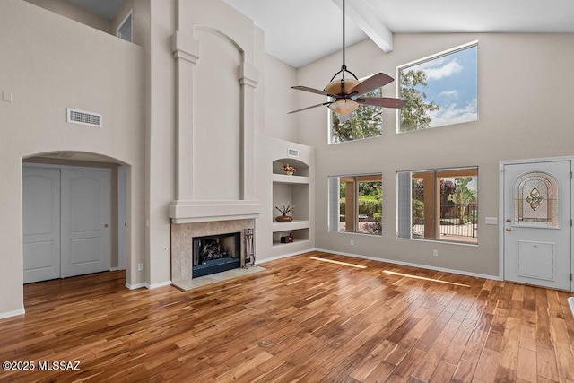 520 E Marshall Peak Dr, Oro Valley, AZ 85755 - unfurnished living room featuring a ceiling fan, high vaulted ceiling, beam ceiling, wood finished floors, and arched walkways