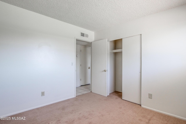 9552 E Irene St, Tucson, AZ 85730 - unfurnished bedroom featuring light carpet, a closet, and a textured ceiling