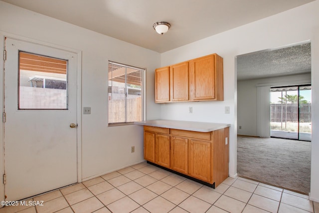 9552 E Irene St, Tucson, AZ 85730 - kitchen featuring light carpet, light countertops, and light tile patterned floors