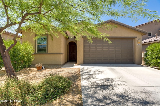 3287 W Sunlit Peak Dr, Tucson, AZ 85742 - view of front of property with a garage, stucco siding, and driveway