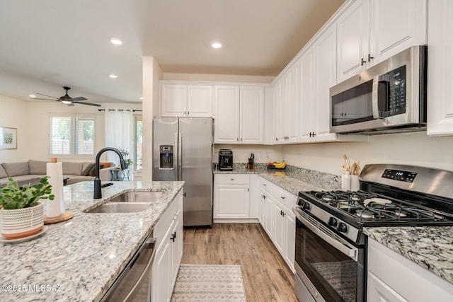 3287 W Sunlit Peak Dr, Tucson, AZ 85742 - kitchen featuring appliances with stainless steel finishes, a sink, light wood-type flooring, white cabinetry, and recessed lighting