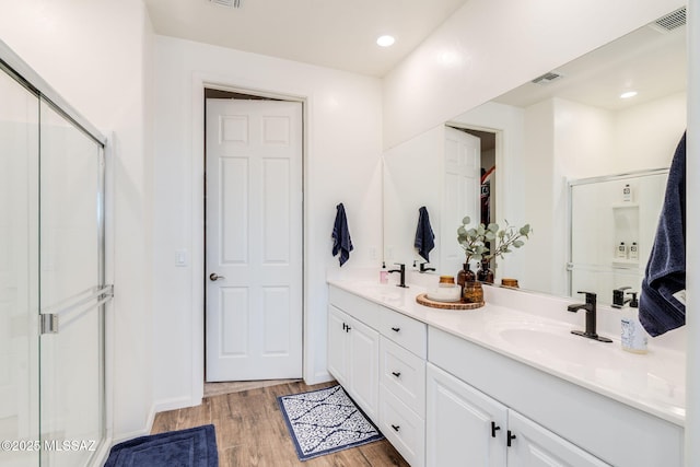 3287 W Sunlit Peak Dr, Tucson, AZ 85742 - bathroom featuring double vanity, a shower stall, and wood finished floors