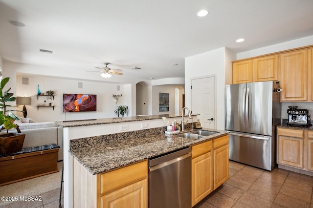 9225 S Summer Breeze Ln, Tucson, AZ 85756 - kitchen with stainless steel appliances, a sink, arched walkways, a ceiling fan, and open floor plan