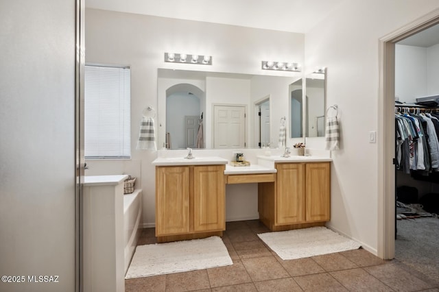 9225 S Summer Breeze Ln, Tucson, AZ 85756 - bathroom with a garden tub, double vanity, tile patterned flooring, a walk in closet, and baseboards