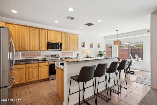 9225 S Summer Breeze Ln, Tucson, AZ 85756 - kitchen with stainless steel appliances, recessed lighting, a breakfast bar area, light tile patterned flooring, and dark stone countertops