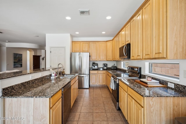 9225 S Summer Breeze Ln, Tucson, AZ 85756 - kitchen with stainless steel appliances, a sink, light brown cabinetry, arched walkways, and recessed lighting
