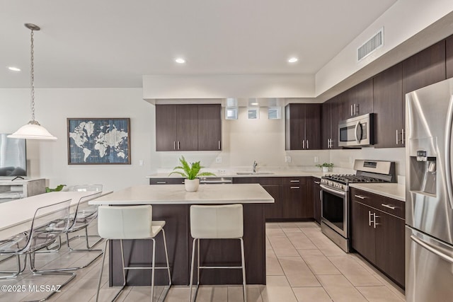 890 E Millenium Ct Unit E, Tucson, AZ 85719 - kitchen featuring appliances with stainless steel finishes, a breakfast bar area, light countertops, light tile patterned floors, and recessed lighting
