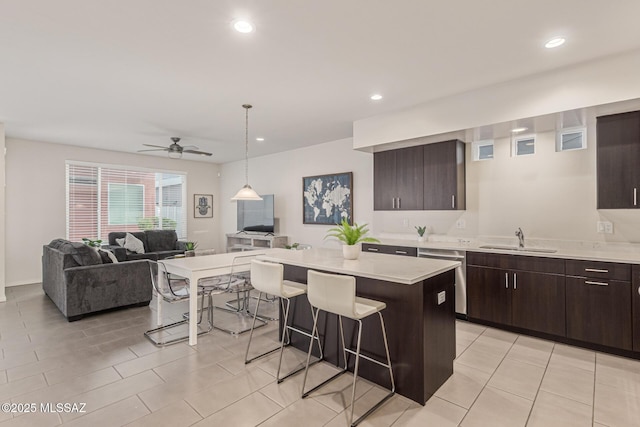 890 E Millenium Ct Unit E, Tucson, AZ 85719 - kitchen with a sink, a breakfast bar area, dishwasher, open floor plan, and light countertops