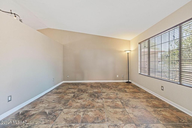 7925 S Danforth Ave, Tucson, AZ 85747 - spare room featuring stone finish floors, baseboards, and vaulted ceiling