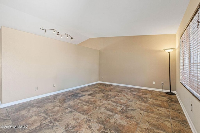 7925 S Danforth Ave, Tucson, AZ 85747 - spare room with stone tile floors, baseboards, and lofted ceiling