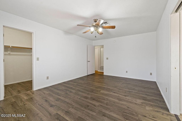 7925 S Danforth Ave, Tucson, AZ 85747 - unfurnished bedroom with dark wood-style floors, baseboards, a spacious closet, and a ceiling fan