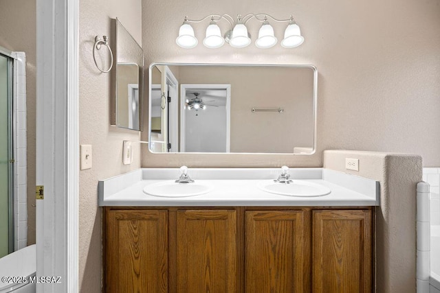 7925 S Danforth Ave, Tucson, AZ 85747 - bathroom featuring double vanity, ceiling fan, a textured wall, and a shower with shower door