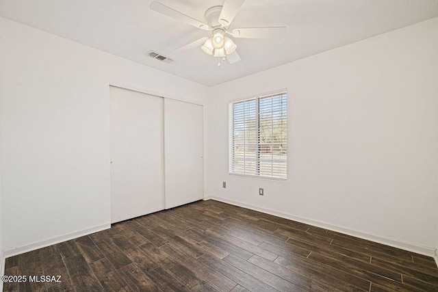 7925 S Danforth Ave, Tucson, AZ 85747 - unfurnished bedroom featuring dark wood-style floors, a closet, baseboards, and a ceiling fan