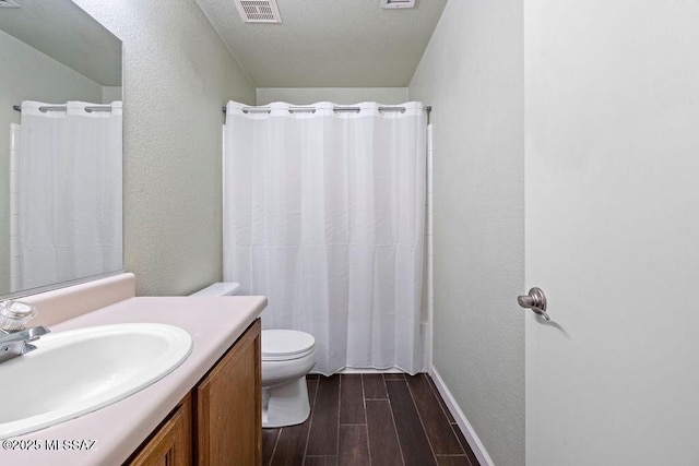 7925 S Danforth Ave, Tucson, AZ 85747 - bathroom with wood finished floors, toilet, vanity, curtained shower, and baseboards
