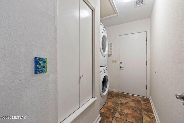 7925 S Danforth Ave, Tucson, AZ 85747 - washroom with stacked washer / dryer, stone finish flooring, and baseboards
