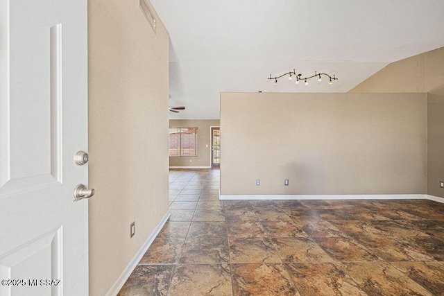 7925 S Danforth Ave, Tucson, AZ 85747 - empty room with ceiling fan, baseboards, stone finish flooring, and vaulted ceiling