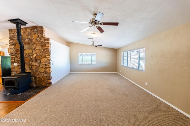 577 W Whitney Ln, Saint David, AZ 85630 - unfurnished living room with a wood stove, plenty of natural light, ceiling fan, and baseboards