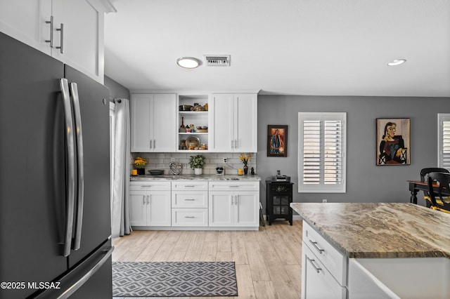9000 N Twain St, Tucson, AZ 85742 - kitchen featuring freestanding refrigerator, open shelves, light wood-type flooring, white cabinetry, and tasteful backsplash