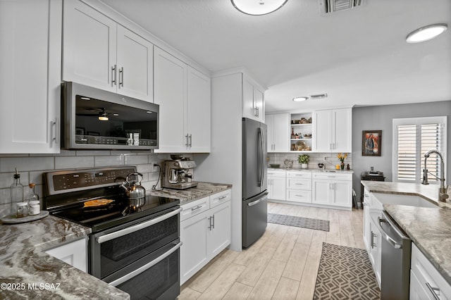 9000 N Twain St, Tucson, AZ 85742 - kitchen with appliances with stainless steel finishes, a sink, backsplash, white cabinetry, and open shelves