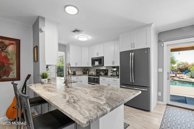 9000 N Twain St, Tucson, AZ 85742 - kitchen featuring stainless steel appliances, a sink, a peninsula, white cabinets, and decorative backsplash