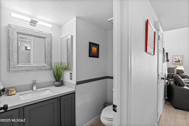 9000 N Twain St, Tucson, AZ 85742 - bathroom featuring vanity, wood finished floors, toilet, and a textured ceiling