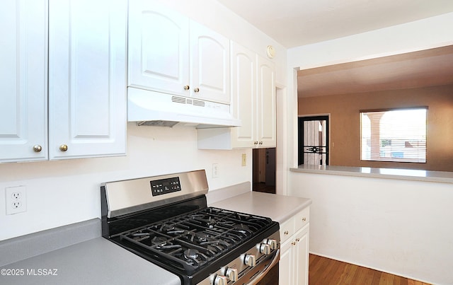 2422 E Drachman St, Tucson, AZ 85719 - kitchen with under cabinet range hood, stainless steel gas range oven, white cabinetry, wood finished floors, and light countertops