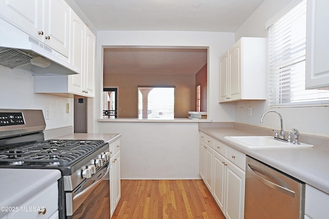 2422 E Drachman St, Tucson, AZ 85719 - kitchen featuring appliances with stainless steel finishes, a sink, under cabinet range hood, and white cabinetry