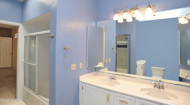 2422 E Drachman St, Tucson, AZ 85719 - bathroom with tile patterned flooring, double vanity, bath / shower combo with glass door, and toilet