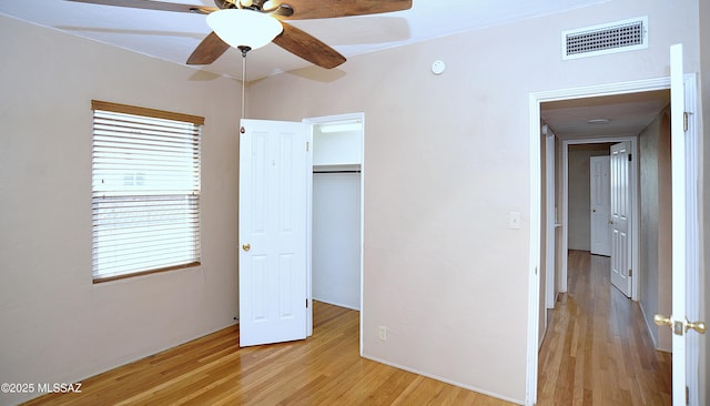 2422 E Drachman St, Tucson, AZ 85719 - unfurnished bedroom featuring light wood-style flooring, multiple windows, a closet, and a ceiling fan
