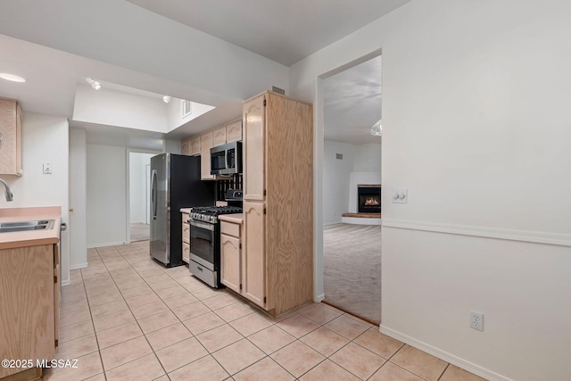 242 E Calle Turquesa, Tucson, AZ 85704 - kitchen with appliances with stainless steel finishes, a sink, light tile patterned floors, light brown cabinets, and light countertops