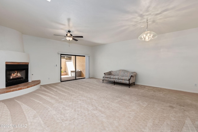 242 E Calle Turquesa, Tucson, AZ 85704 - unfurnished living room featuring light carpet, a lit fireplace, ceiling fan, and baseboards