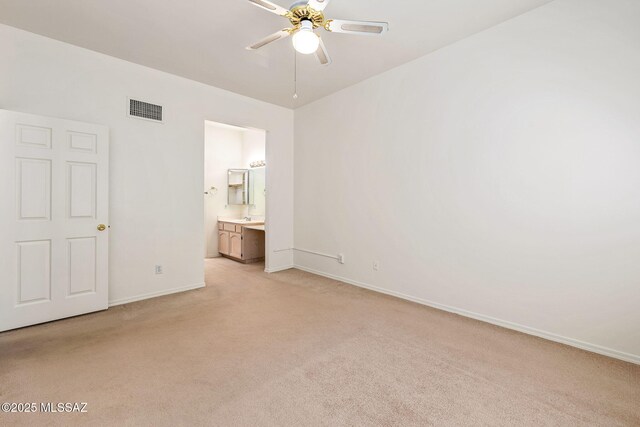 242 E Calle Turquesa, Tucson, AZ 85704 - unfurnished bedroom featuring light carpet, baseboards, ensuite bathroom, and ceiling fan
