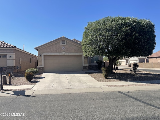 15808 S Via Cayetano, Sahuarita, AZ 85629 - view of front of house featuring a garage, concrete driveway, stucco siding, and stone siding